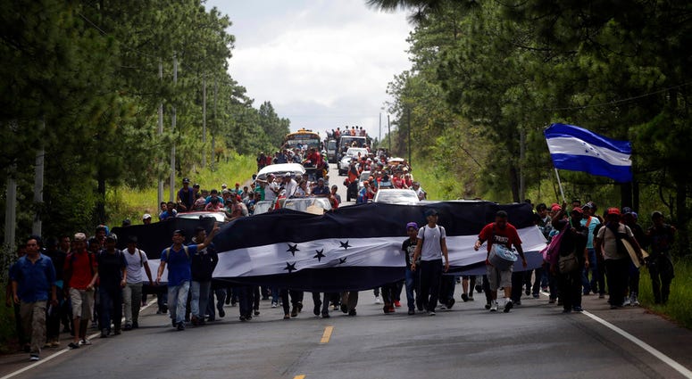Hondurans march in a caravan of migrants moving toward the country's border with Guatemala in a desperate attempt to flee poverty and seek new lives in the United States, on Monday, Oct. 15, 2018. (AP Photo/Moises Castillo)