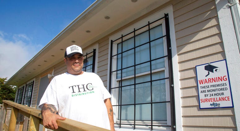 In this Oct. 4, 2018, file photo, Thomas Clarke poses for a photo outside his cannabis store, THC Distribution, in Portugal Cove-St. Philip's, Newfoundland and Labrador.