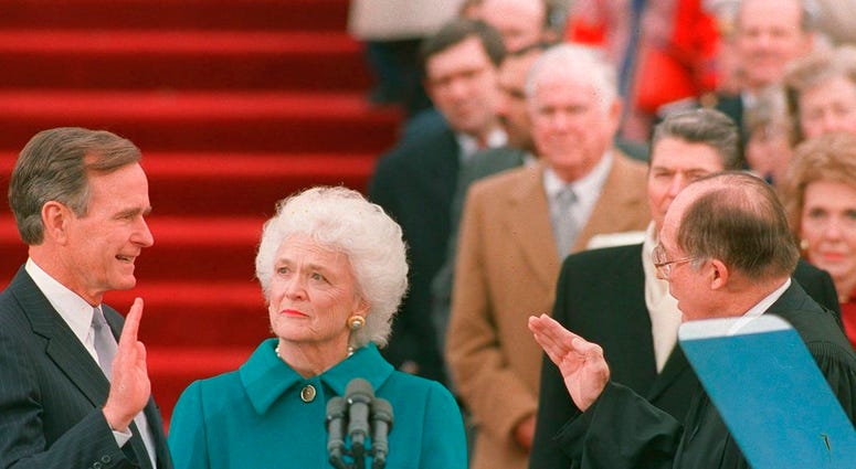 In this Jan. 20, 1989, file photo, President George H.W. Bush raises his right hand as he is sworn into office as the 41st president of the United States by Chief Justice William Rehnquist