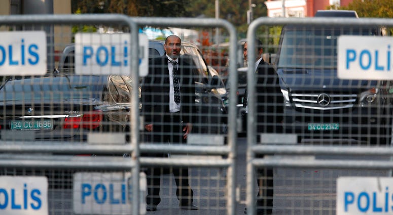 Security personnel guarding Saudi Arabia's consulate are seen behind barriers blocking the road leading to the diplomatic mission, in Istanbul, Monday, Oct. 22, 2018. (AP Photo/Lefteris Pitarakis)