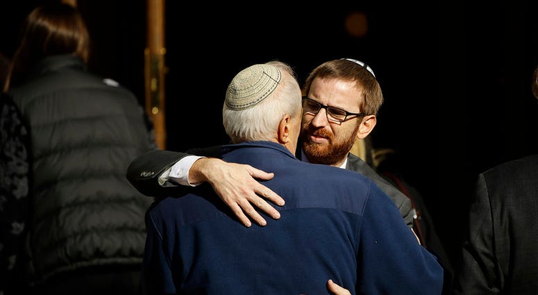 Mourners hug outside Rodef Shalom Congregation during the funeral services for brothers Cecil and David Rosenthal, Tuesday, Oct. 30, 2018, in Pittsburgh.
