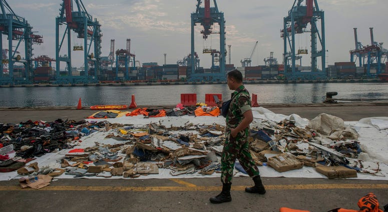 soldier walks past plane debris