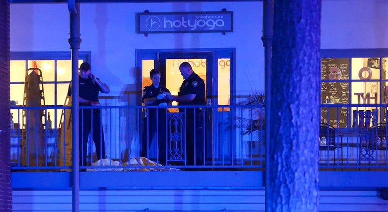 Police investigators work the scene of a shooting, Friday, Nov. 2, 2018, in Tallahassee, Fla. A shooter killed one person and critically wounded four others at a yoga studio in Florida's capital before killing himself Friday,