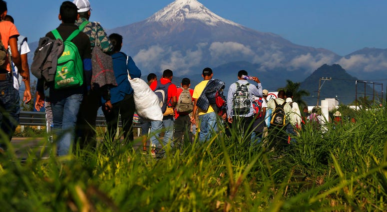 Central American migrants begin their morning trek as part of a thousands-strong caravan hoping to reach the U.S. border, as they face the Pico de Orizaba volcano
