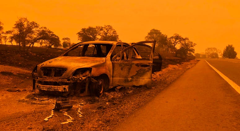 A burned out car sits on the side of the road in Paradise, Calif., Friday, Nov. 9, 2018, after a wildfire swept through the area.