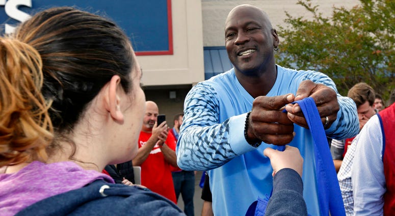 harlotte Hornets owner Michael Jordan greets people and hands out food for Thanksgiving to members of the community in Wilmington, N.C., Tuesday, Nov. 20, 2018.