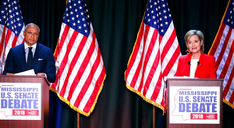 Appointed U.S. Sen. Cindy Hyde-Smith, R-Miss., answers a question while Democrat Mike Espy, left, listens during their televised Mississippi U.S. Senate debate in Jackson, Miss., Tuesday, Nov. 20, 2018.