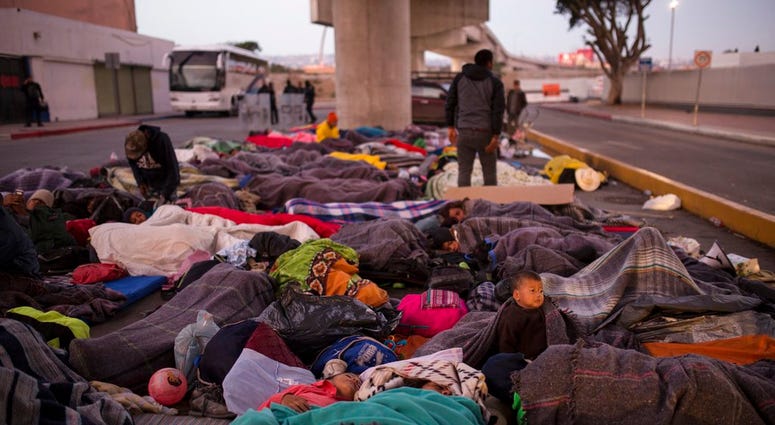 Migrants sleep under a bridge at the Chaparral border crossing in Tijuana, Mexico, Friday, Nov. 23, 2018.