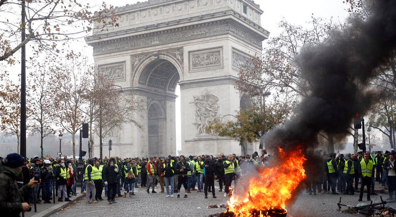 Demonstrators, called the yellow jackets, gather around the Arc de Triomphe as they protest against the fuel taxes, in Paris, France, Saturday, Nov. 24, 2018.