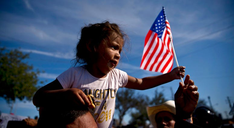 Migrant girl with American flag
