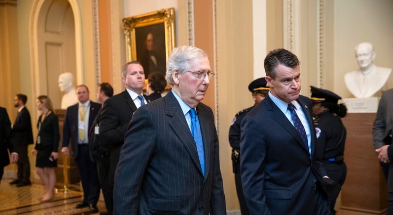 Senate Majority Leader Mitch McConnell, R-Ky., joined by Sen. Todd Young, R-Ind., right, walk to a meeting with fellow Republicans at the Capitol in Washington, Tuesday, Nov. 27, 2018.