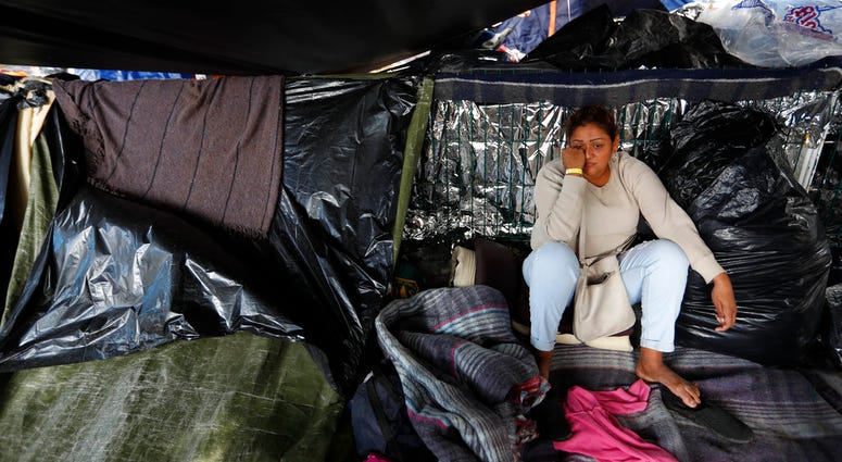 A woman from El Salvador waits to see whether the majority of migrants decide to move