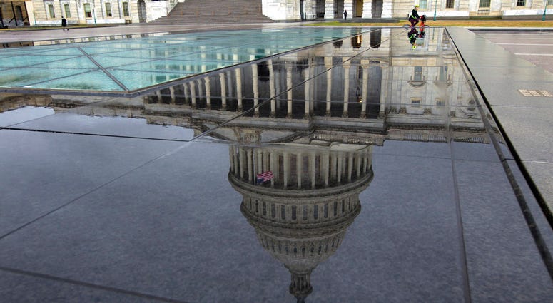 The U.S. Capitol is seen reflected after rain in Washington, Friday, Dec. 21, 2018.
