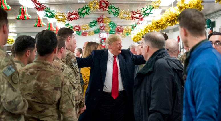 President Donald Trump visits with members of the military at a dining hall at Al Asad Air Base, Iraq, Wednesday, Dec. 26, 2018. (AP Photo/Andrew Harnik)