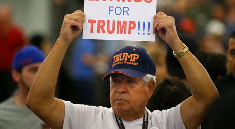 Man holding sign at Trump campaign rally