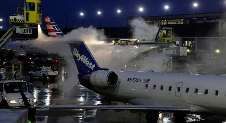 A deicing agent is applied to a SkyWest airplane before its takeoff, Friday, Jan. 18, 2019, at O'Hare International Airport in Chicago.