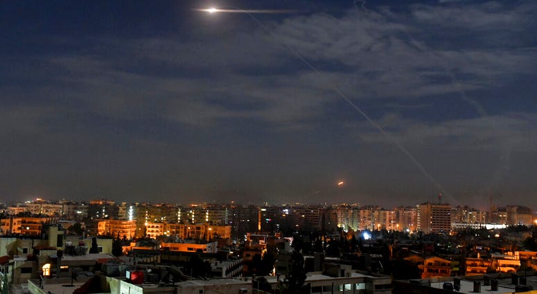 This photo released by the Syrian official news agency SANA, shows missiles flying into the sky near international airport, in Damascus, Syria, Monday, Jan. 21, 2019