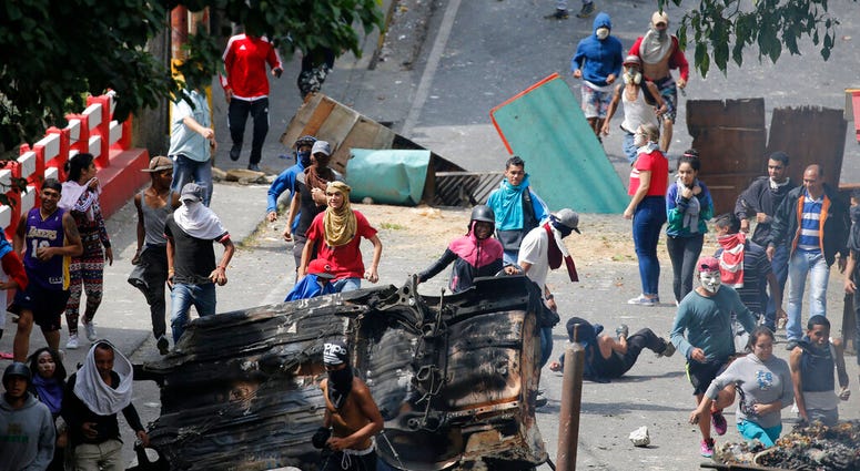 Anti-government protesters face off with security forces as they show support for an apparent mutiny by a national guard unit in the Cotiza neighborhood of Caracas, Venezuela, Monday, Jan. 21, 2019