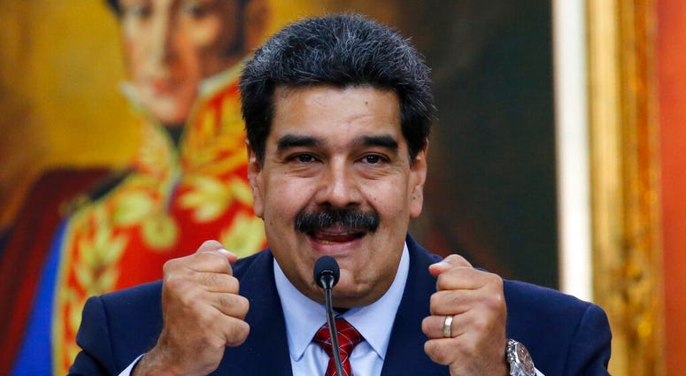 Venezuelan President Nicolas Maduro holds up his fists during a press conference at Miraflores presidential palace in Caracas, Venezuela, Friday, Jan. 25, 2019,