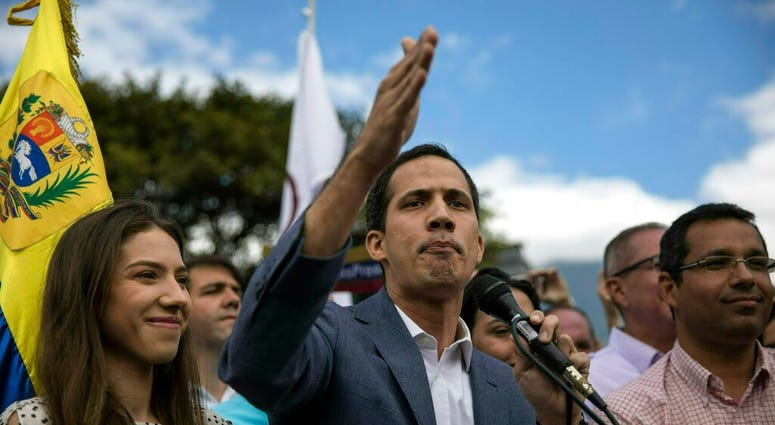 Venezuela's self-declared interim leader Juan Guaido, accompanied by his wife Fabiana Rosales, speaks to supporters in Las Mercedes neighborhood of Caracas, Venezuela, Saturday, Jan. 26, 2019.