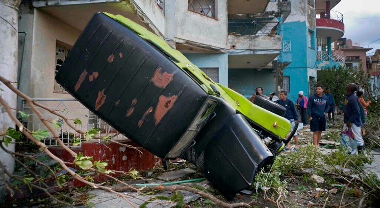 A truck is toppled against a home after a tornado in Havana, Cuba, Monday, Jan. 28, 2019