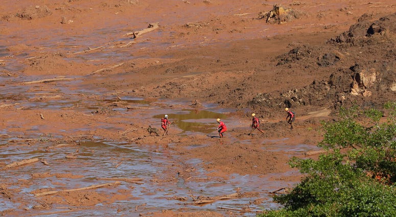Rescue workers look for victims in the mud at a site where a hotel used to be, days after a dam collapse in Brumadinho, Brazil, Monday, Jan. 28, 2019.