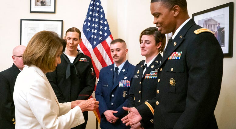 Speaker of the House Nancy Pelosi, D-Calif., left, gives challenge coins to U.S. Army Maj. Ian Brown, right, and other military service members to thank them for their service. (Julio Obscura/Office of the Speaker of the House Nancy Pelosi via AP) Speaker of the House Nancy Pelosi, D-Calif., left, gives challenge coins to U.S. Army Maj. Ian Brown, right, and other military service members to thank them for their service. (Julio Obscura/Office of the Speaker of the House Nancy Pelosi via AP)