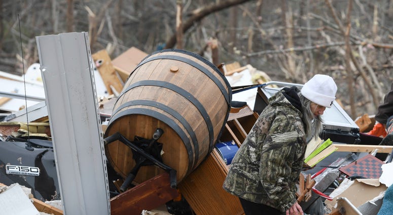 Julie Morrison looks through the debris of her home in Beauregard, Ala