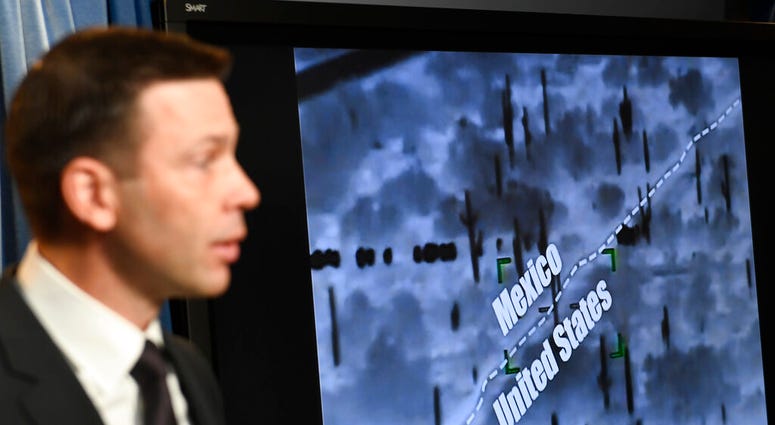 With surveillance footage in the background, U.S. Customs and Border Patrol Commissioner Kevin McAleenan speaks during a news conference in Washington, Tuesday, March 5, 2019.(AP Photo/Susan Walsh)