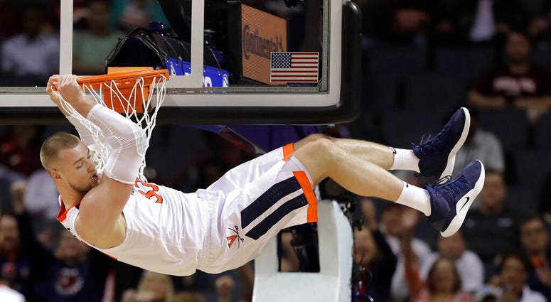 Virginia's Jack Salt (33) hangs from the rim after a dunk against North Carolina State during the second half of an NCAA college basketball game in the Atlantic Coast Conference tournament in Charlotte, N.C., March 14, 2019. (AP Photo/Chuck Burton)