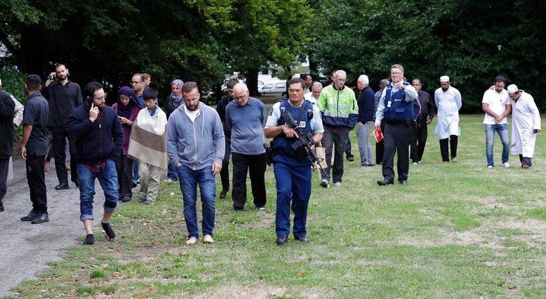 Police escort people from a mosque in Christchurch