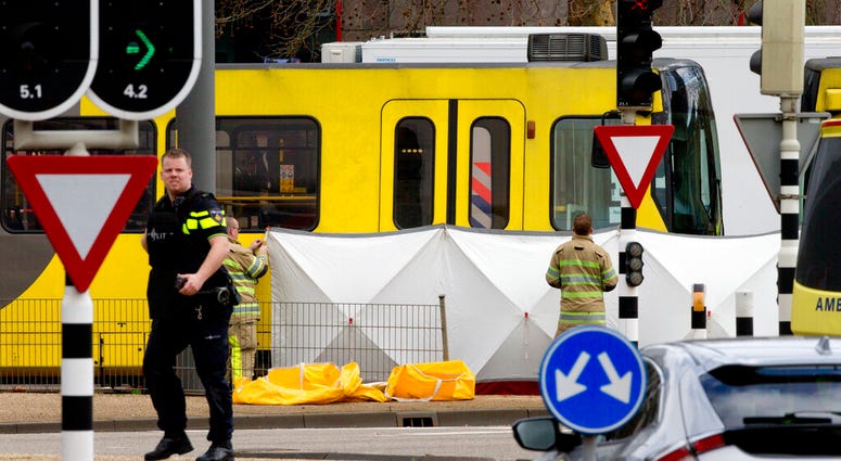 Rescue workers install a screen on the spot where a body was covered with a white blanket following a shooting in Utrecht, Netherlands, Monday, March 18, 2019. (AP Photo/Peter Dejong)