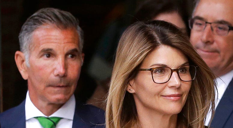 In this April 3, 2019 file photo, actress Lori Loughlin, front, and husband, clothing designer Mossimo Giannulli, left, depart federal court in Boston after facing charges in a nationwide college admissions bribery scandal. (AP Photo/Steven Senne, File)