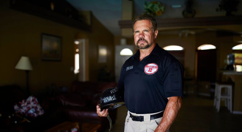Grant Whitus poses for a portrait at his home in Lake Havasu City, Ariz. Whitus' marriage fell apart a year after he led his SWAT team into Columbine High School's library, where he was the first to find the dead children's bodies. (AP Photo/John Locher) Grant Whitus poses for a portrait at his home in Lake Havasu City, Ariz. Whitus' marriage fell apart a year after he led his SWAT team into Columbine High School's library, where he was the first to find the dead children's bodies. (AP Photo/John Locher)