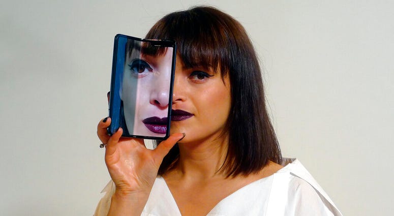 A model holds a Samsung Galaxy Fold smartphone to her face, during a media preview event in London. (AP Photo/Kelvin Chan) A model holds a Samsung Galaxy Fold smartphone to her face, during a media preview event in London. (AP Photo/Kelvin Chan)