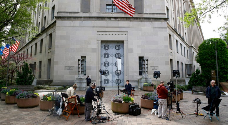 Television news crews work outside the Department of Justice building, Wednesday, April 17, 2019, in Washington. (AP Photo/Patrick Semansky)