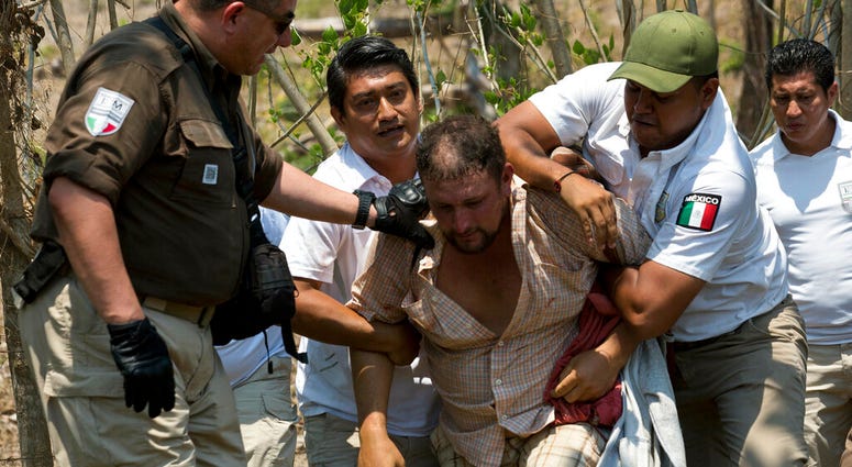 Mexican Immigration officials detain a migrant