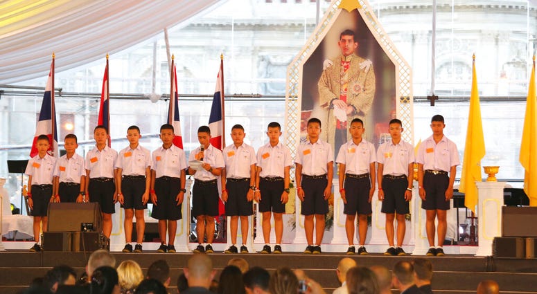 FILE - In this Sept. 6, 2018. file photo, members of the Wild Boars, the soccer team that was rescued from a flooded cave, give thanks in front of Thailand King Maha Vajiralongkorn's image. (AP Photo/Sakchai Lalit, File) FILE - In this Sept. 6, 2018. file photo, members of the Wild Boars, the soccer team that was rescued from a flooded cave, give thanks in front of Thailand King Maha Vajiralongkorn's image. (AP Photo/Sakchai Lalit, File)