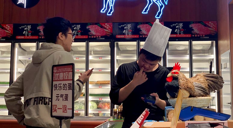 A worker at the imported beef section of a supermarket that used to carry U.S. products chats with another in Beijing on Tuesday, May 14, 2019. (AP Photo/Ng Han Guan)