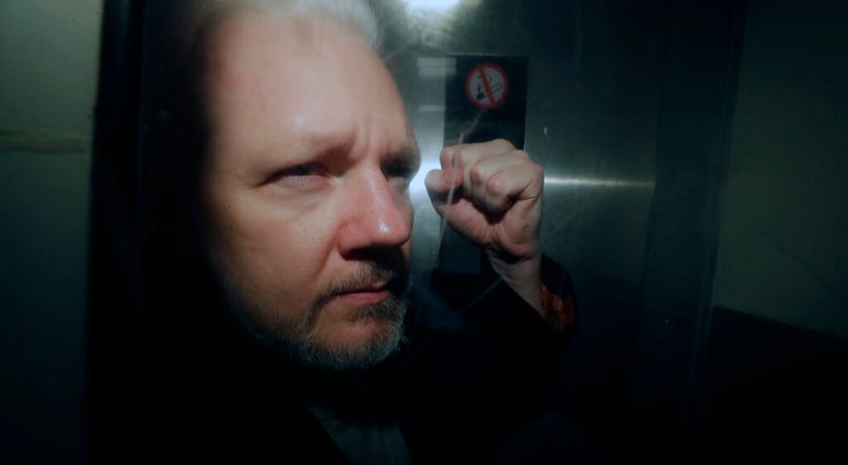 In this May 1, 2019, file photo, WikiLeaks founder Julian Assange puts his fist up as he is taken from court in London. (AP Photo/Matt Dunham, File)