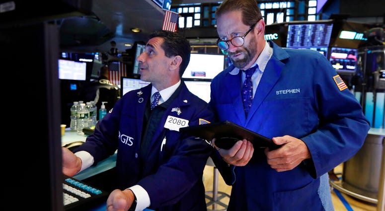 FILE - In this May 28, 2019, file photo specialist Peter Mazza, left, and trader Stephen Gilmartin work on the floor of the New York Stock Exchange. The U.S. stock market opens at 9:30 a.m. EDT on Friday, May 31. (AP Photo/Richard Drew, File)