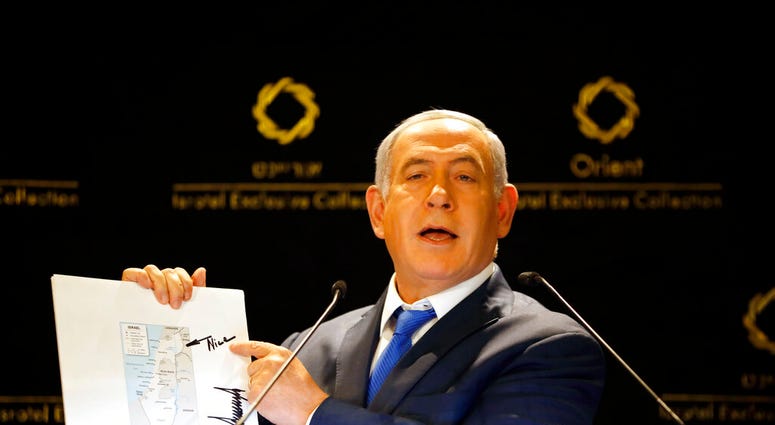 Israeli Prime Minister Benjamin Netanyahu shows a map from US President Donald Trump during statements to the press in Jerusalem, Thursday, May 30, 2019. President Donald Trump's son-in-law and senior adviser Jared Kushner met with Israeli Prime Minister