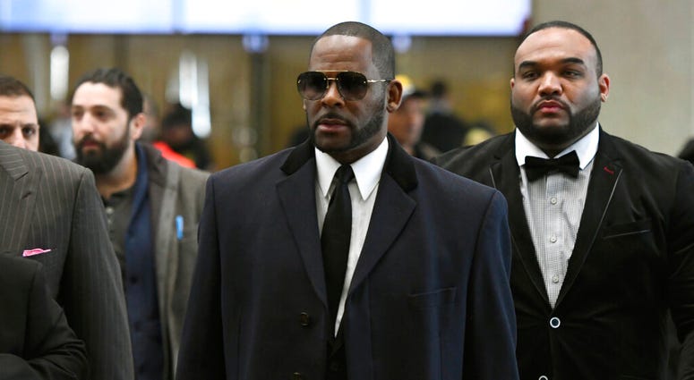 El cantante R. Kelly, en el centro, llega a un juzgado en Chicago para una audiencia el martes 7 de mayo del 2019. (AP Foto/Matt Marton)