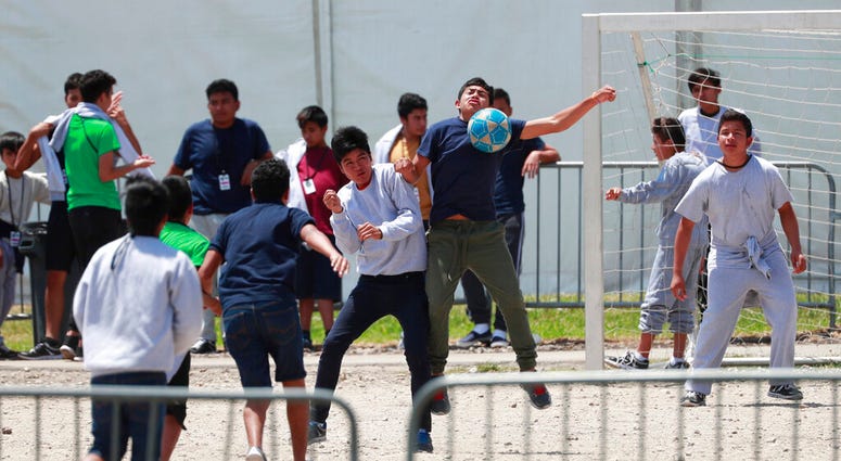 In this April 19, 2019 file photo, migrant children play soccer at the Homestead Temporary Shelter for Unaccompanied Children on Good Friday in Homestead, Fla. (AP Photo/Wilfredo Lee, File)