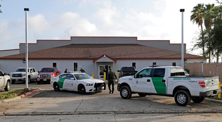 FILE - In this Saturday, June 23, 2018, file photo, a U.S. Border Patrol Agent walks between vehicles outside the Central Processing Center in McAllen, Texas. Advocates were shocked to find an underage mom and her tiny, premature newborn daughter huddled