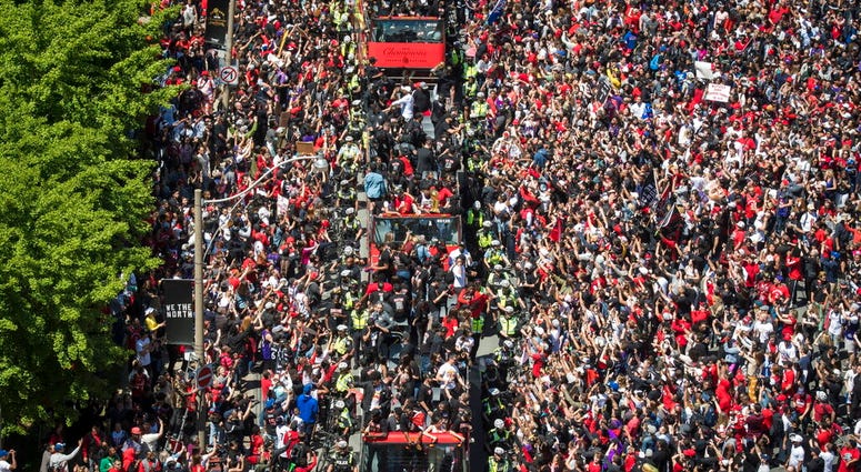 Members of the Toronto Raptors NBA basketball championship team ride on buses during a victory parade in Toronto, Monday, June 17, 2019. (Tijana Martin/The Canadian Press via AP)
