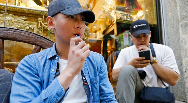 In this Monday, June 17, 2019, photo, Joshua Ni, 24, and Fritz Ramirez, 23, vape from electronic cigarettes in San Francisco. (AP Photo/Samantha Maldonado) In this Monday, June 17, 2019, photo, Joshua Ni, 24, and Fritz Ramirez, 23, vape from electronic cigarettes in San Francisco. (AP Photo/Samantha Maldonado)