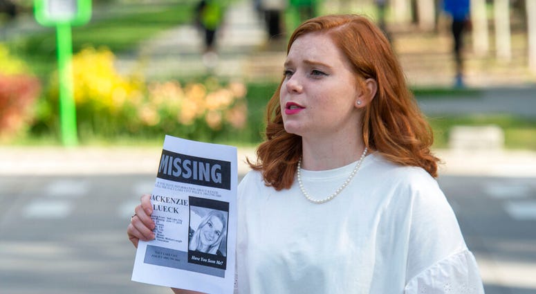 In this Saturday, June 22, 2019 photo, Ashley Fine stops motorists in Liberty Park in Salt Lake City, as she hands out flyers with Mackenzie Lueck's photo on it. Police and friends are investigating the disappearance of the 23-year-old University of Utah