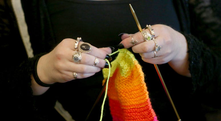 FILE - This April 30, 2018 file photo shows a woman knitting in Silverdale Wash. A free, 8-million strong social network for knitters, crocheters and others in the fiber arts has banned any talk of President Donald Trump and his administration. The new po