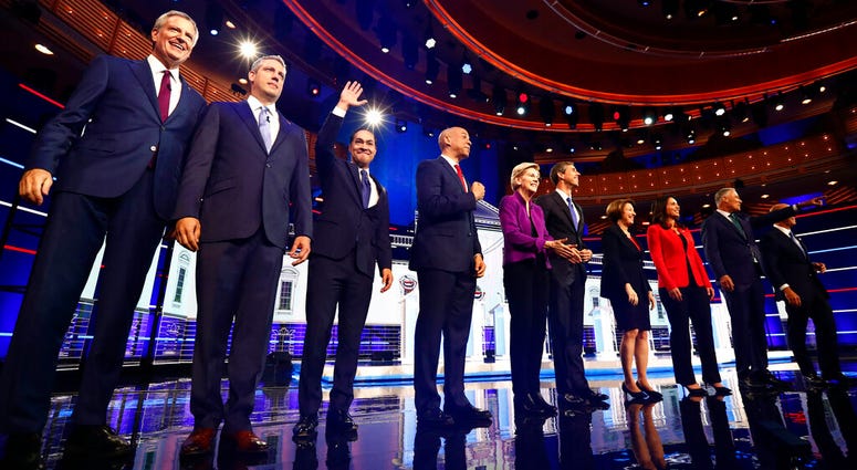 Candidates pose for a photo on stage before the start of a Democratic primary debate hosted by NBC News at the Adrienne Arsht Center for the Performing Arts, Wednesday, June 26, 2019, in Miami. (AP Photo/Brynn Anderson)